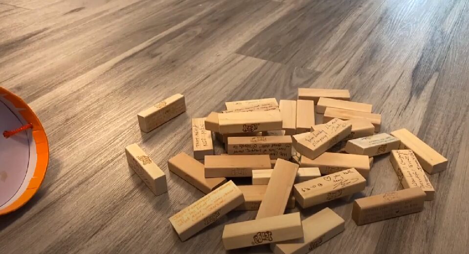 A pile of Jenga blocks with ideas for self care written on each block