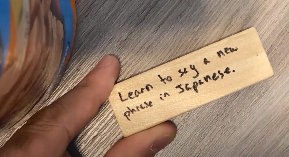 A Jenga block with "Learn to say a new phrase in Japanese" written on it, as one example of self care a CASSY staff member likes to practice