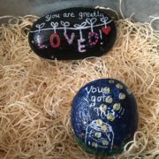 Painted rocks with encouraging messages like "You are greatly loved." and "You got this!"