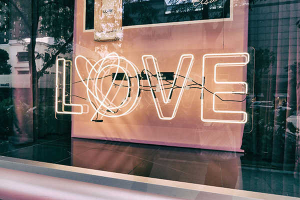 A neon sign in a shop window which reads "LOVE"