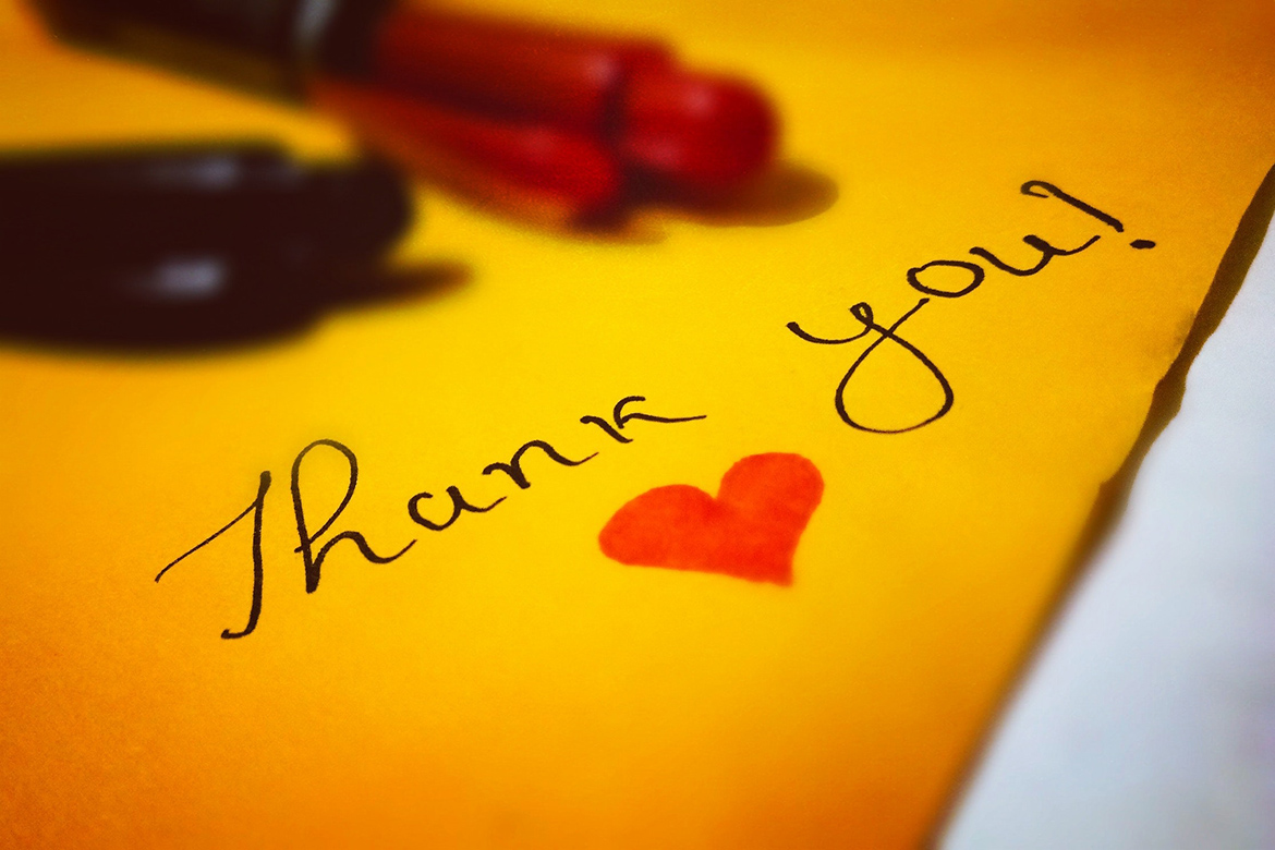 A bright, handwritten note with a heart on it which reads "Thank you!"