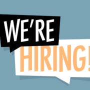 A recruitment banner reading 'We're Hiring!' with bold orange letters in overlapping speech-bubble shapes on a blue background.